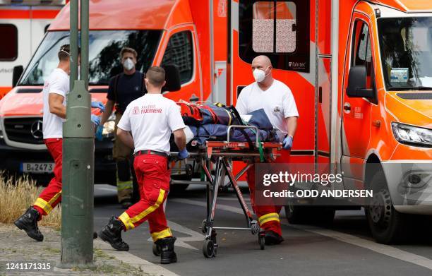 An injured person is transported off the site where one person was killed and eight injured when a car drove into a group of people in central...