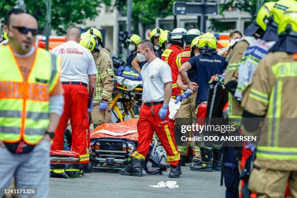 Rescue workers help injured people at the site where one person was killed and eight injured when a car drove into a group of people in central...