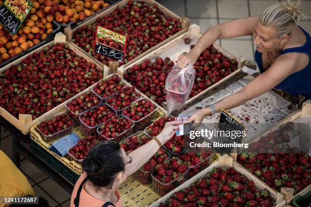 Customer pays for fresh strawberries at a market stall in Lehel Market Hall in Budapest, Hungary, on Tuesday, June 7, 2022. Inflation in Hungary...