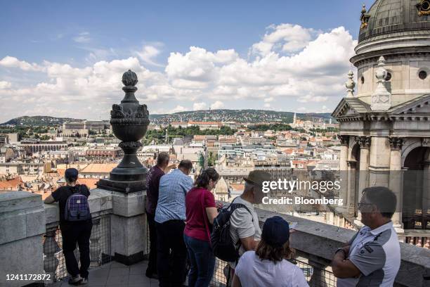 Tourists look out across city rooftops from a viewing area at St. Stephen's Basilica in Budapest, Hungary, on Tuesday, June 7, 2022. Inflation in...