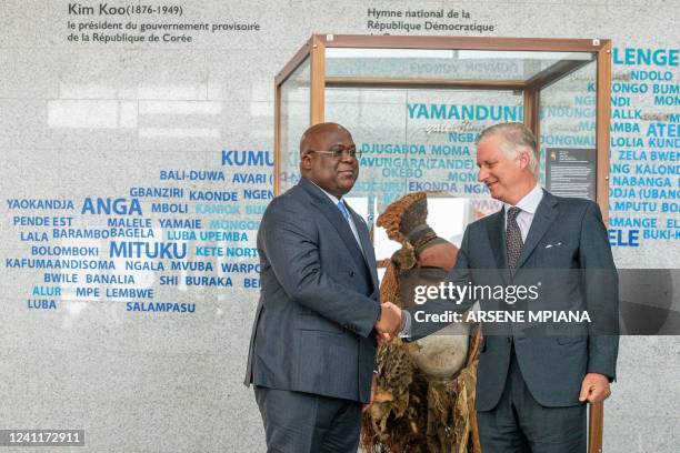 Belgium's King Philippe shakes hands with President of the Democratic Republic of the Congo Felix Tshisekedi as he hands over a ceremonial mask...