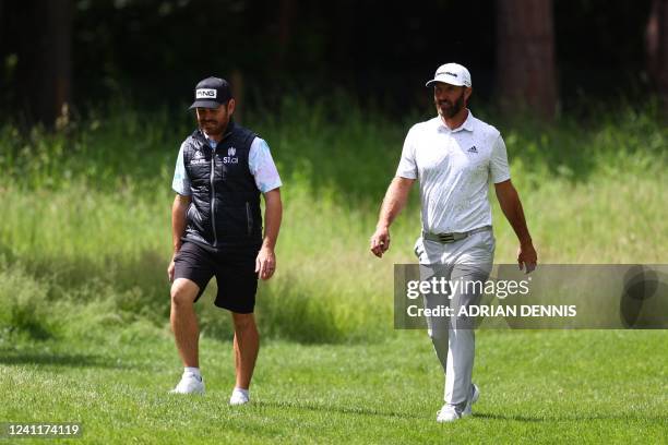 South African golf player Louis Oosthuizen and US golf player Dustin Johnson walk as they take part in the Pro-Am round of the LIV Golf Invitational...