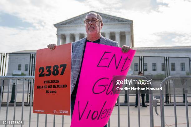 Protester holds signs calling for an end to gun violence in front of the Supreme Court on June 8, 2022 in Washington, DC. The court is expected to...