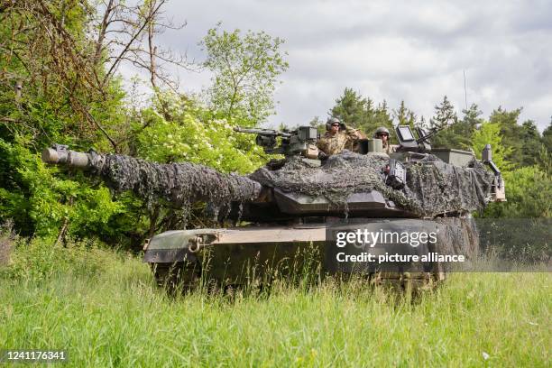 June 2022, Bavaria, Hohenfels: U.S. Soldiers stand with an M1 Abrams tank in a wooded area during a multinational exercise at the Hohenfels training...