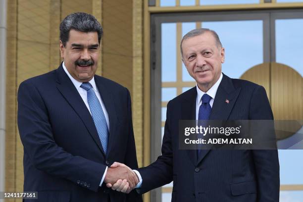 Turkish President Recep Tayyip Erdogan shakes hands with his Venezuelan counterpart Nicolas Maduro during an official welcoming ceremony in Ankara,...