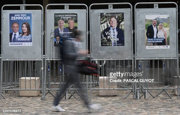 Man passes by electoral posters of candidates in the ninth constituency of the southern France department of Herault, on June 8, 2022 in Montpellier,...
