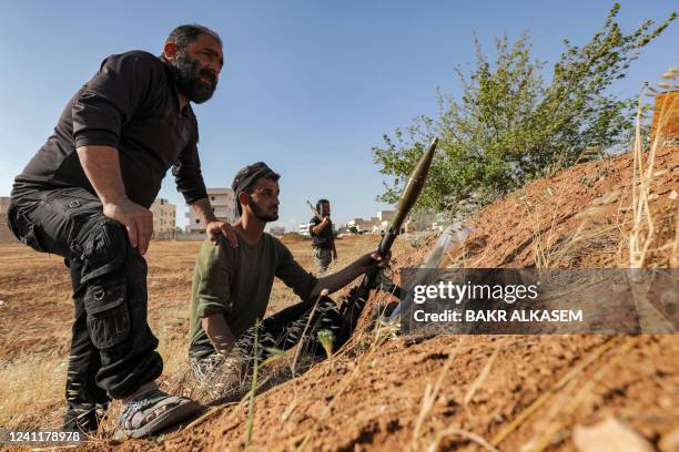 One of Turkish-backed Syrian rebel fighters holds a rocket-propelled grenade launcher while sitting at a position along the battle frontlines with...