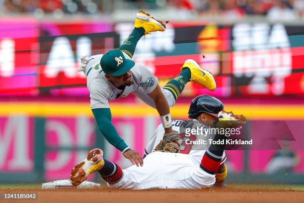 Ronald Acuna Jr. #13 of the Atlanta Braves is tagged out by Tony Kemp of the Oakland Athletics on a base steal attempt during the first inning at...