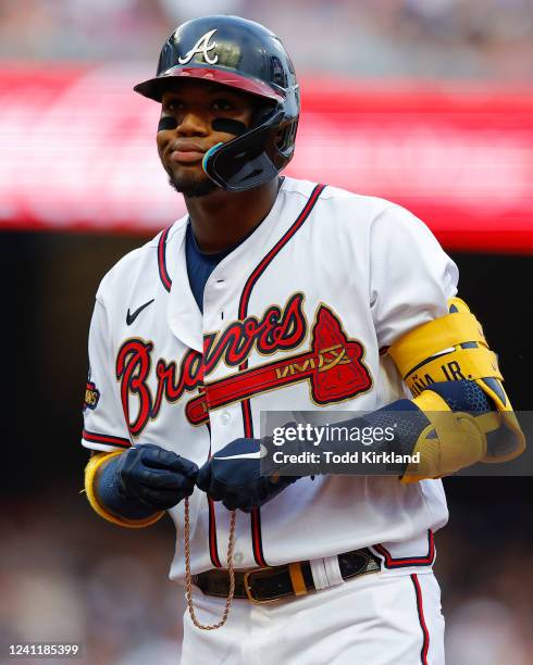 Ronald Acuna Jr. #13 of the Atlanta Braves reacts as his necklace is broken after a hit during the first inning against the Oakland Athletics at...