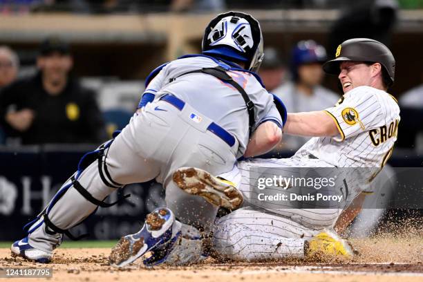 Jake Cronenworth of the San Diego Padres collides with Tomas Nido of the New York Mets as he scores during the third inning of a baseball game at...