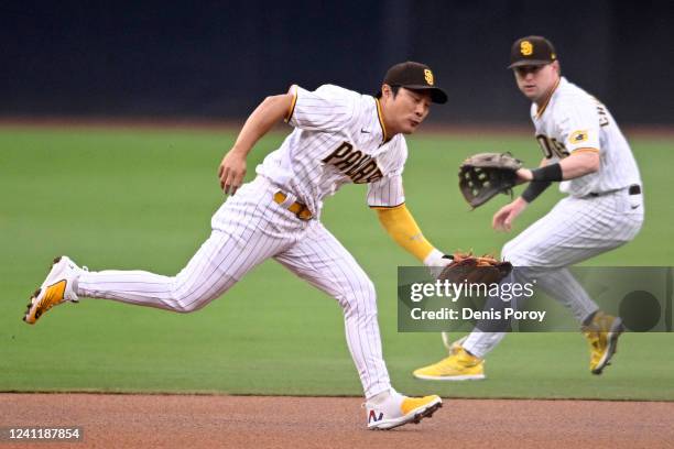 Ha-Seong Kim of the San Diego Padres fields a ball hit by Mark Canha of the New York Mets as teammate Jake Cronenworth looks on during the first...