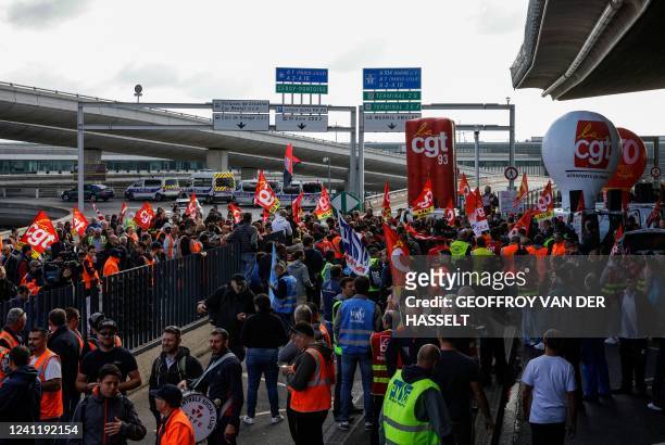 Paris Charles de Gaulle airport employees congregate outside a terminal as they stage a strike to demand higher wages at Roissy Charles De Gaulle...