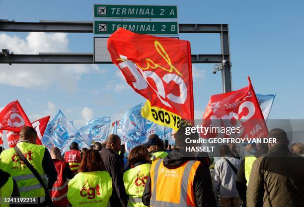 Paris Charles de Gaulle airport employees wave trade union flags as they stage a strike to demand higher wages at Roissy Charles De Gaulle Airport,...