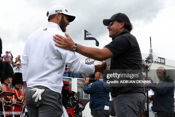 Golfer Dustin Johnson shakes hands with US golfer Phil Mickelson on the first tee on the first day of the LIV Golf Invitational Series event at The...