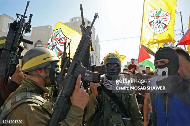 Armed and masked members of the Fatah movement march in the funeral of 27-year-old Palestinian Mahmud Fayez Abu Ayhour, in Halhul, north of the West...