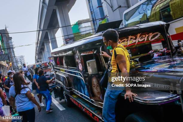 Jeepney dispatcher sits at the hood of a moving jeepney while calling passengers. Diesel fuel, most commonly used for Public Utility Jeepneys , a...