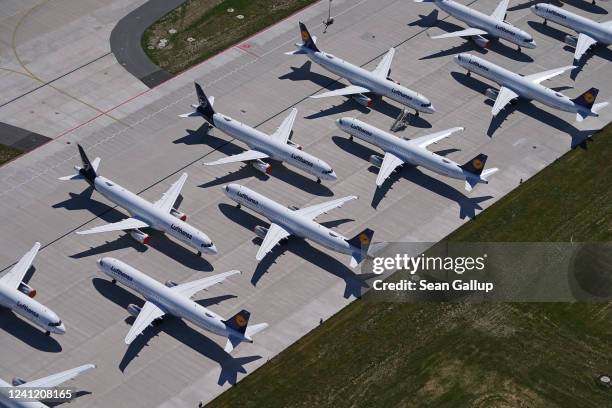 Passenger planes of airline Lufthansa that have been temporarily pulled out of service stand parked at Berlin-Brandenburg Airport during the...