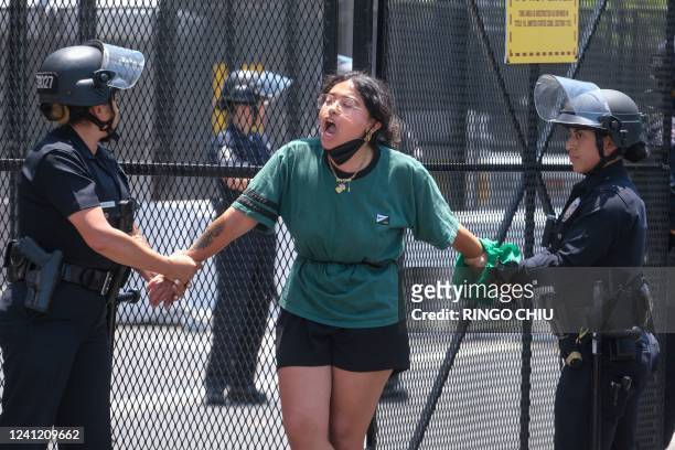 Police officers arrest an Abortion Rights protester who chained herself to a fence during a protest outside the Convention Center where the 9th...