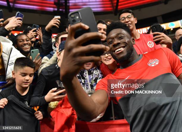 Canada's midfielder Alphonso Davies signs autographs and takes photos with fans following the Concacaf Nations League football match between Canada...