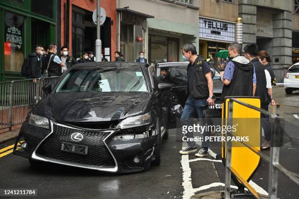 Police inspect the scene of a gang clash overnight that left one man with a gunshot wound and two others injured, in Hong Kong on June 10, 2022.