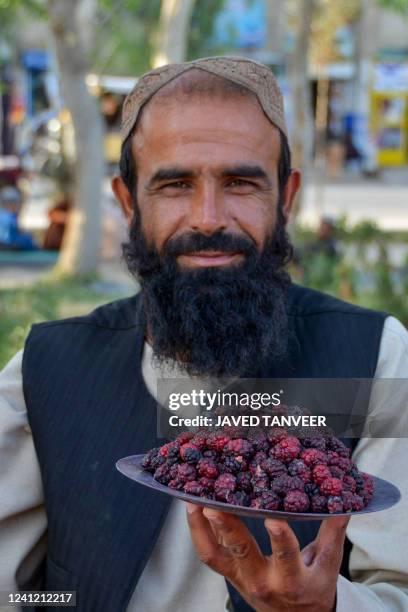 In this picture taken on June 9 a man sells mulberries by the roadside in Kandahar.