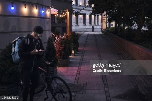 Wolt food delivery courier checks their phone in Wroclaw, Poland, on Thursday, June 9, 2022. Poland's central bank signaled no letup in its campaign...