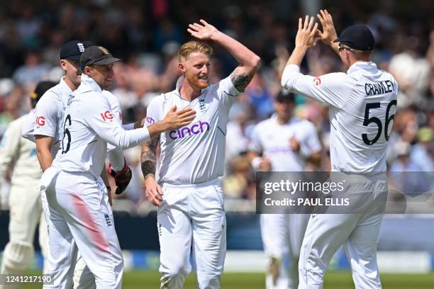 England's captain Ben Stokes celebrates with teammates after taking the wicket of New Zealand's Henry Nicholls for 30 runs on the first day of the...