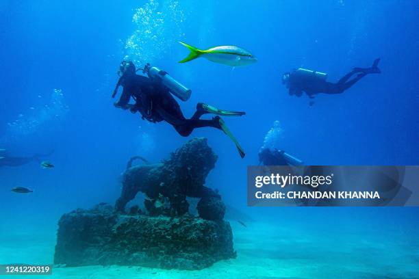 Scuba divers swim through the man-made Neptune Memorial Reef, 3.25 miles off the coast of Key Biscayne, Florida, on May 14, 2022. - Divers swim near...