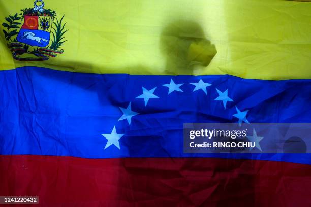 Activists carry a Venezuelan flag as they protest outside the 9th Summit of the Americas at the LA Convention Center to deliver a letter rejecting...