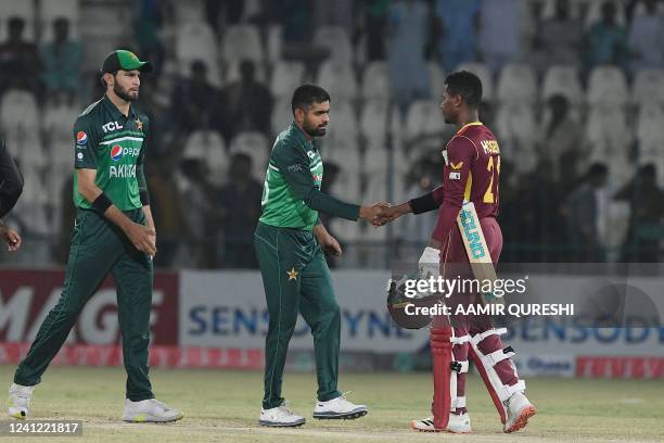 Pakistan's captain Babar Azam shakes hands with West Indies' player Akeal Hosein after their victory on the second one-day international cricket...