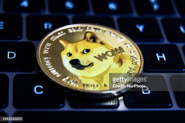 Representation of Dogecoin and a laptop keyboard are seen in this illustration photo taken in Krakow, Poland on June 10, 2022.