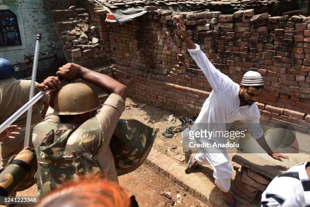 Indian Security personnel baton charge on protestors to disperse them during a protest over insulting remarks against Prophet Muhammad by some...