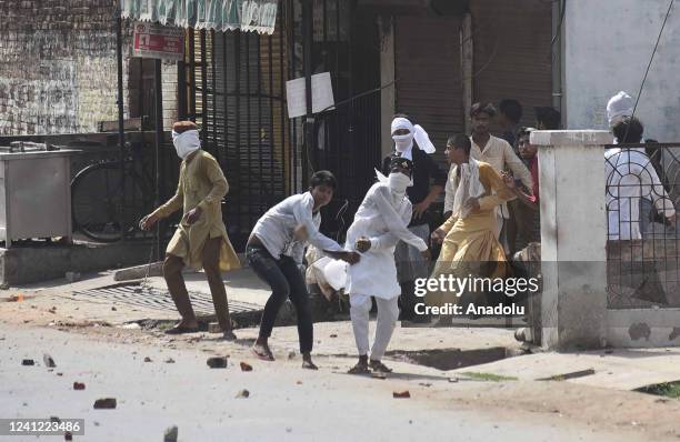 Protestors throw stones towards Indian Security personnel during a protest over insulting remarks against Prophet Muhammad by some officials of the...