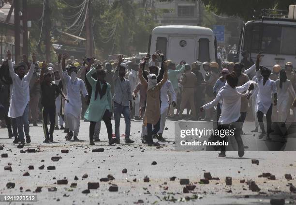 Protestors throw stones towards Indian Security personnel during a protest over insulting remarks against Prophet Muhammad by some officials of the...