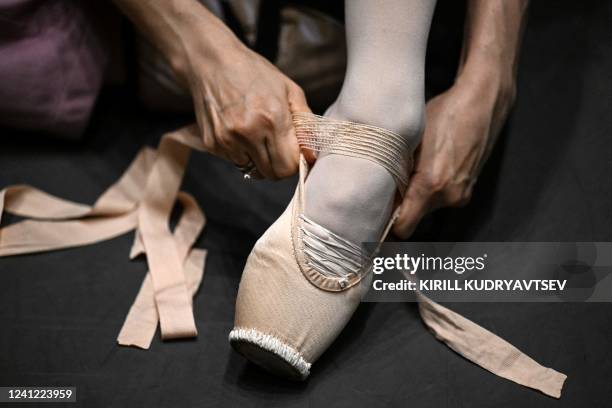 Dancer puts her pointe shoes prior to the final tour of the XIV International Ballet Competition at the Bolshoi theatre in Moscow on June 10, 2022.