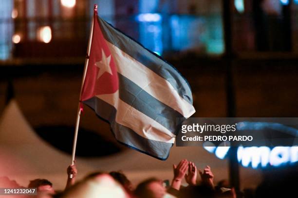 Fan of Cuban singer Silvio Rodriguez holds a Cuban flag during his concert in the Zocalo square in Mexico City, on June 10, 2022.