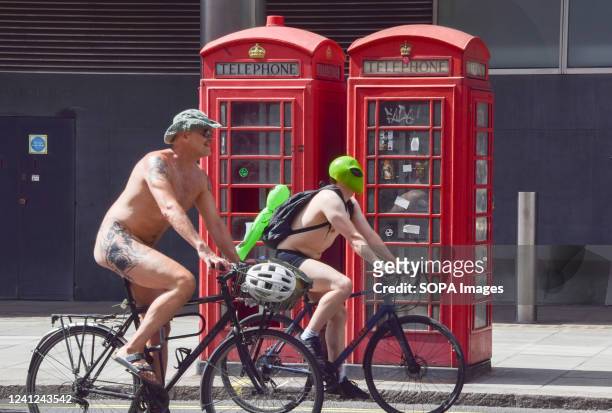 Nude cyclists pass by red telephone boxes as part of this years World Naked Bike Ride. Thousands of nude and partially nude people took part in the...