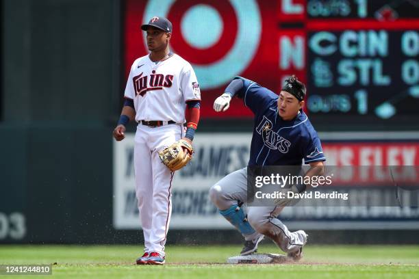 Ji-Man Choi of the Tampa Bay Rays slides into second base after hitting an RBI single while Jorge Polanco of the Minnesota Twins looks on in the...