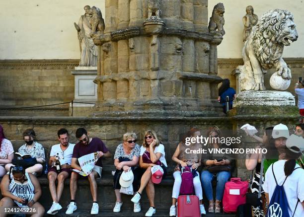 Tourists take a rest in Florence's Piazza della Signoria on June 11, 2022.