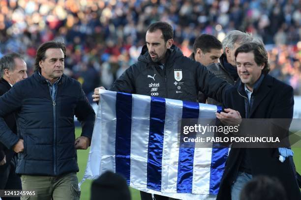 Uruguayan President Luis Lacalle Pou walks next to Uruguay's captain Diego Godin and Uruguayan Football Association president Ignacio Alonso, after...