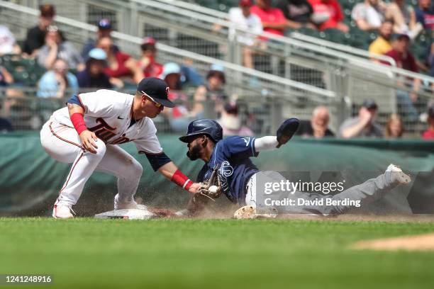 Jose Miranda of the Minnesota Twins tags out Vidal Brujan of the Tampa Bay Rays on a steal attempt at third base in the fifth inning of the game at...