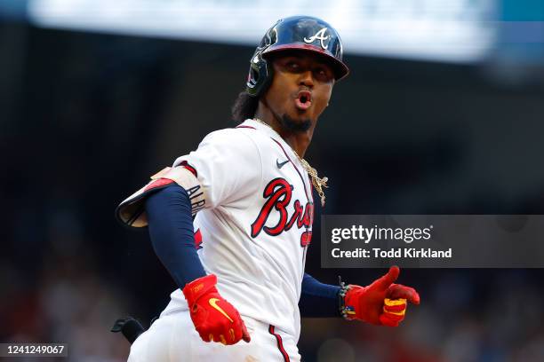 Ozzie Albies of the Atlanta Braves reacts as he rounds first after hitting a grand slam during the seventh inning against the Pittsburgh Pirates at...