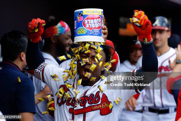 Ozzie Albies of the Atlanta Braves reacts as he has a bucket of bubblegum dumped on his head following a grand slam during the seventh inning against...