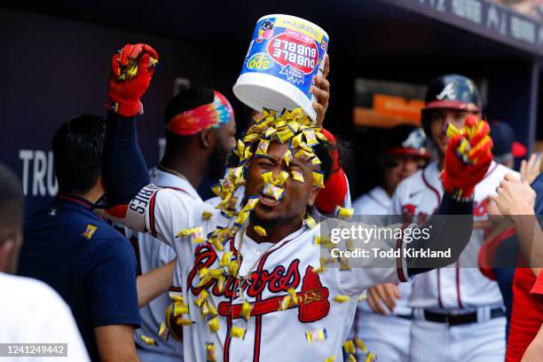 Ozzie Albies of the Atlanta Braves reacts as he has a bucket of bubblegum dumped on his head following a grand slam during the seventh inning against...