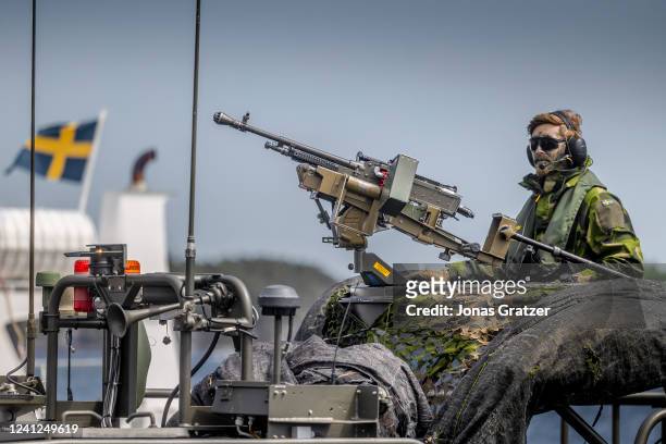 Swedish soldier sits on a military boat with a machine gun during the Baltic Operations NATO military drills on June 11, 2022 in the Stockholm...