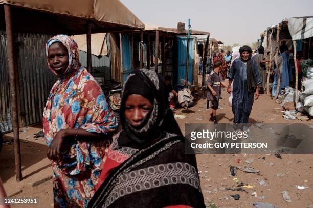 People walk through the weekly market in M'Berra camp in Bassikounou on June 7, 2022. - M'Berra camp, in South East Mauritania, is one the largest...
