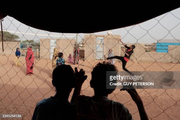 Kids watch a volleyball game in the evening in M'Berra camp in Bassikounou on June 8, 2022. - M'Berra camp, in South East Mauritania, is one the...