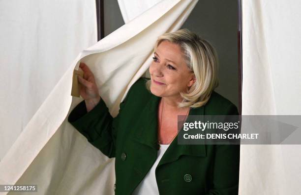 French far-right party Rassemblement National leader Marine Le Pen leaves a booth to cast her vote in French parliamentary elections at a polling...