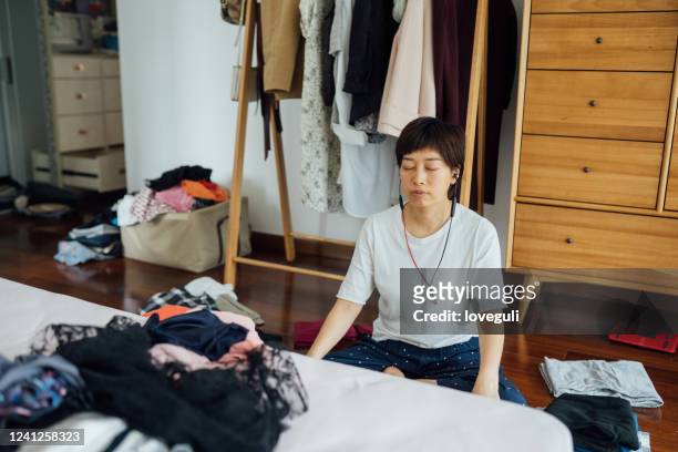 woman with headset sits on the floor in the modern bedroom - tidy room stock pictures, royalty-free photos & images