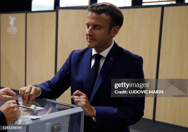 France's President Emmanuel Macron casts his vote in French parliamentary elections at a polling station in Le Touquet, northern France on June 12,...